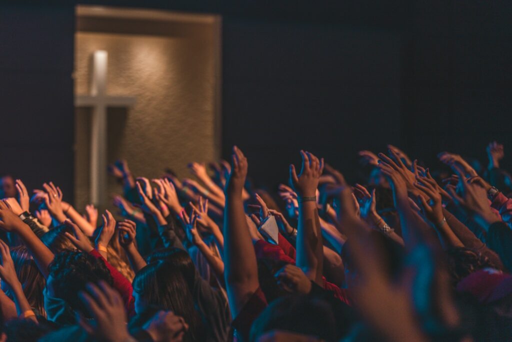 Worship crowd with raised hands singing the I Speak Jesus lyrics by Charity Gayle