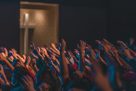 Worship crowd with raised hands singing the I Speak Jesus lyrics by Charity Gayle